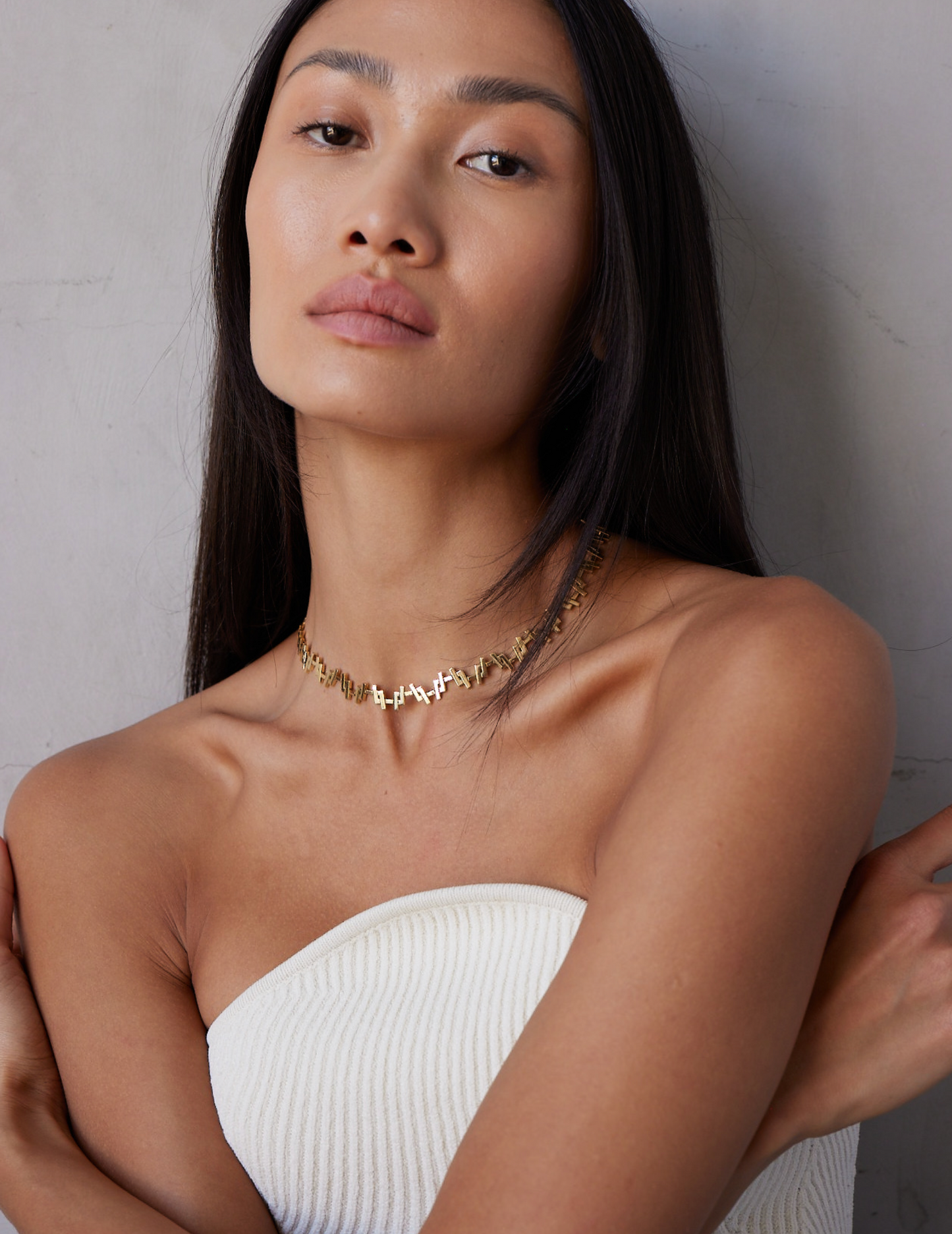 a female model wearing an 18k Gold chain link necklace on a white background