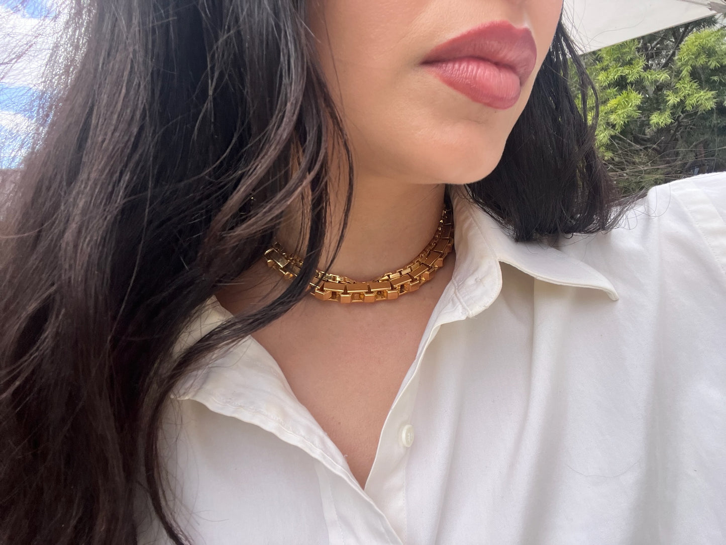 Person wearing our yellow Empire chain and empire strand necklaces with a blurred outdoor background