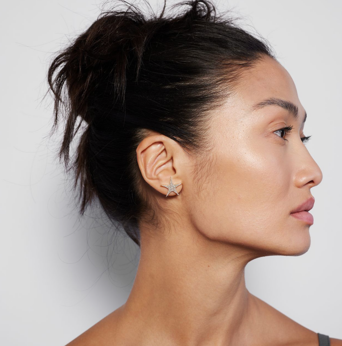 Model wearing a gold star stud with pavé diamonds