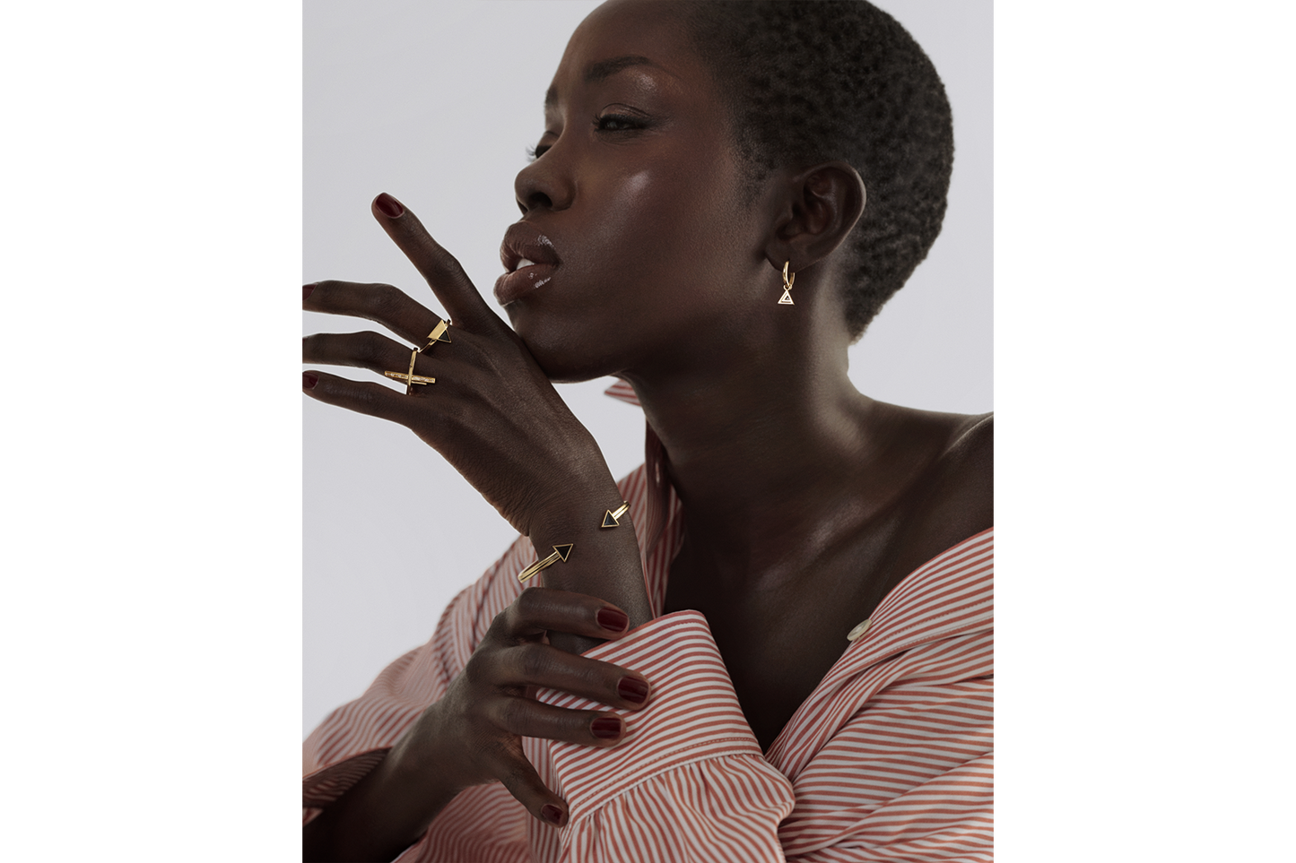 model wearing a gold open bangle with black enamel piping