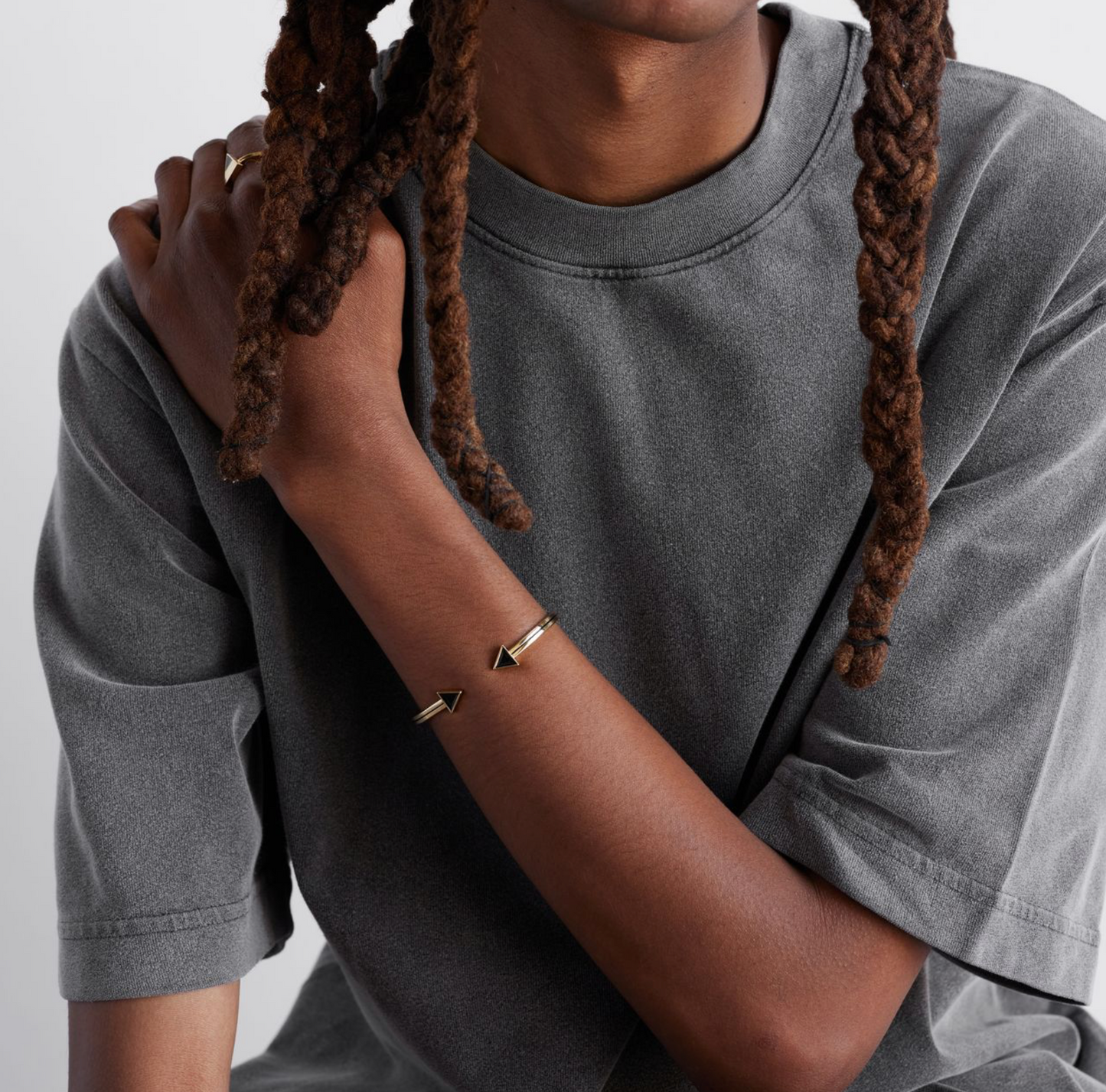 a model shot of a gold bracelet with a chain of linked half-moon crescent shapes, crafted in an Art Deco style.