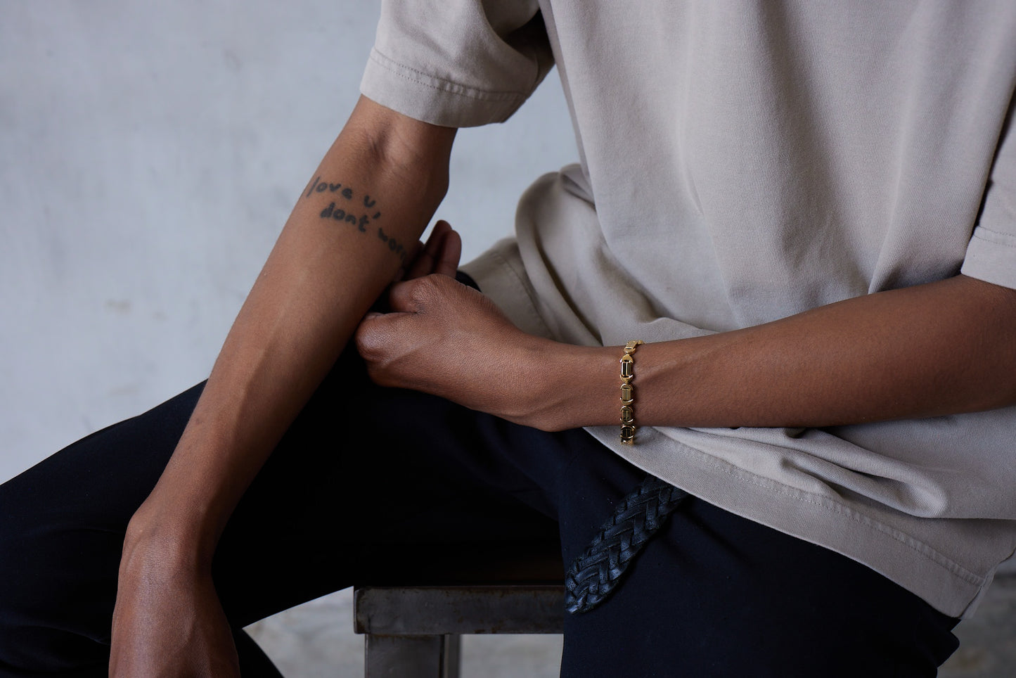 A model shot of a gold bracelet with a chain of linked half-moon crescent shapes, crafted in an Art Deco style.