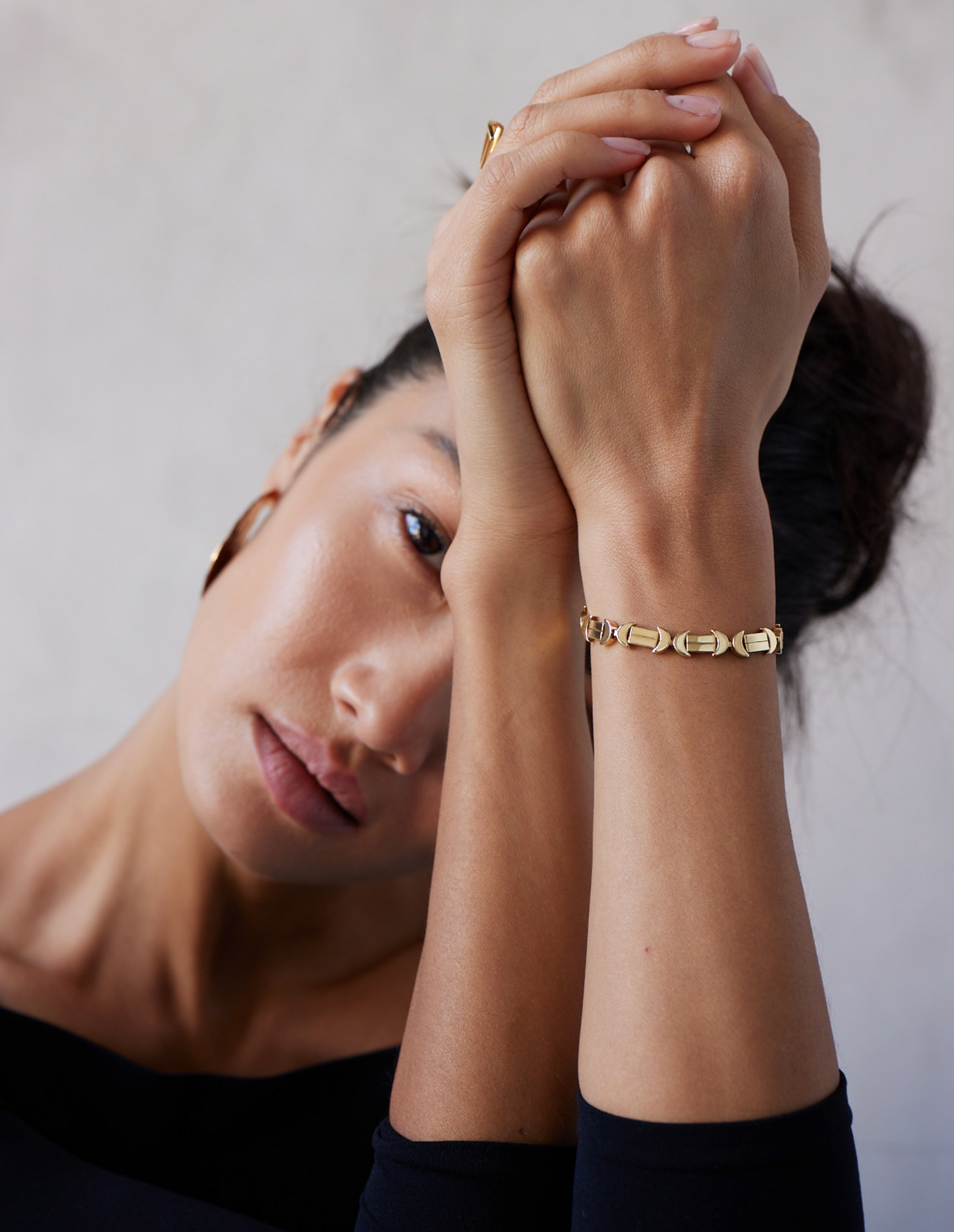 A gold bracelet with a chain of linked half-moon crescent shapes, crafted in an Art Deco style.