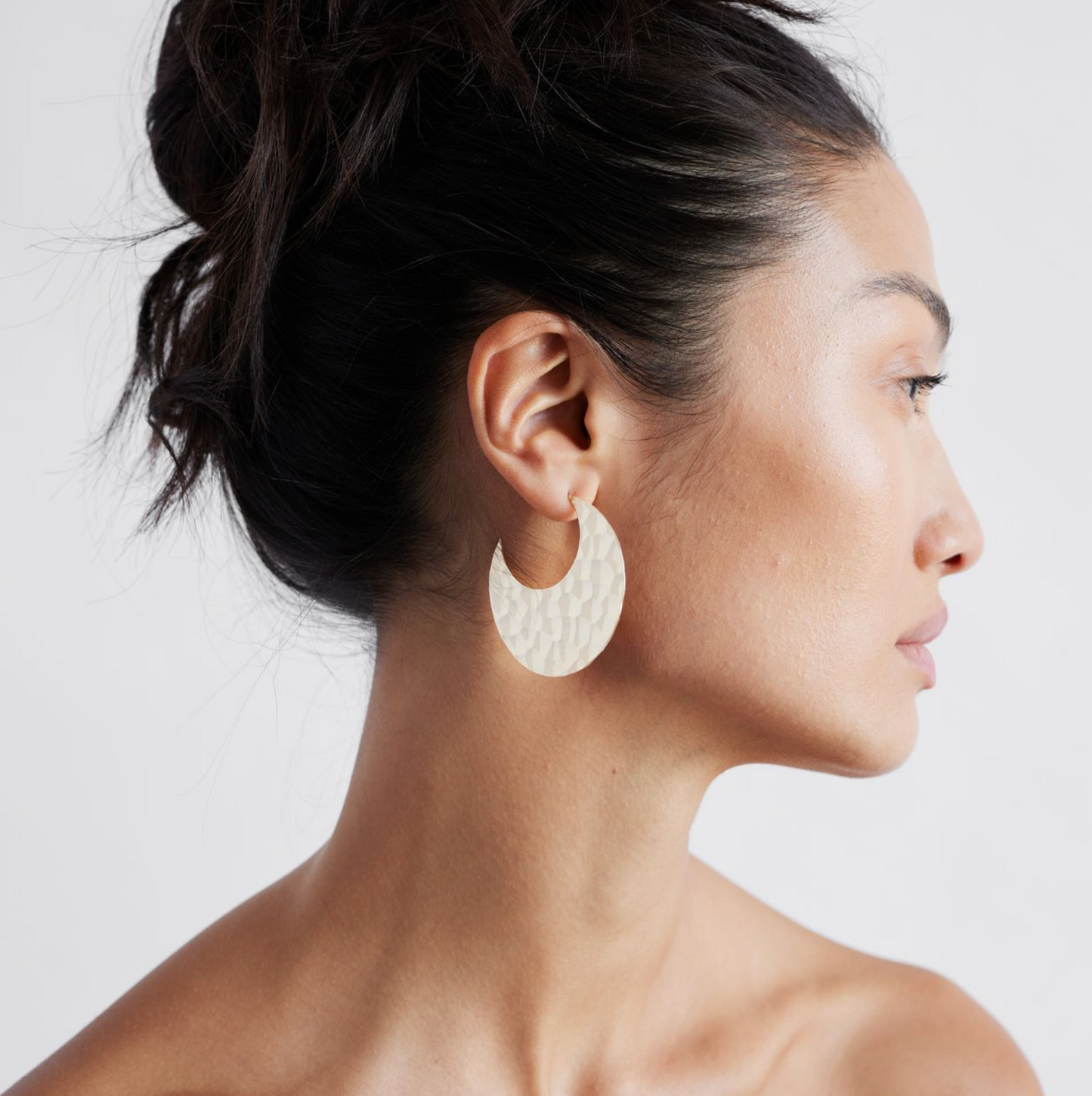 A pair of 14K solid gold hammered hoop earrings with a textured surface, displayed against a white background.