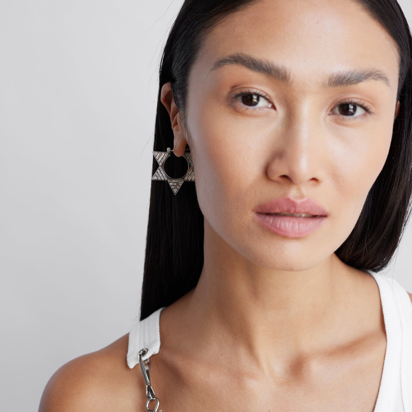 female model close up wearing double sided white gold and diamond hoops