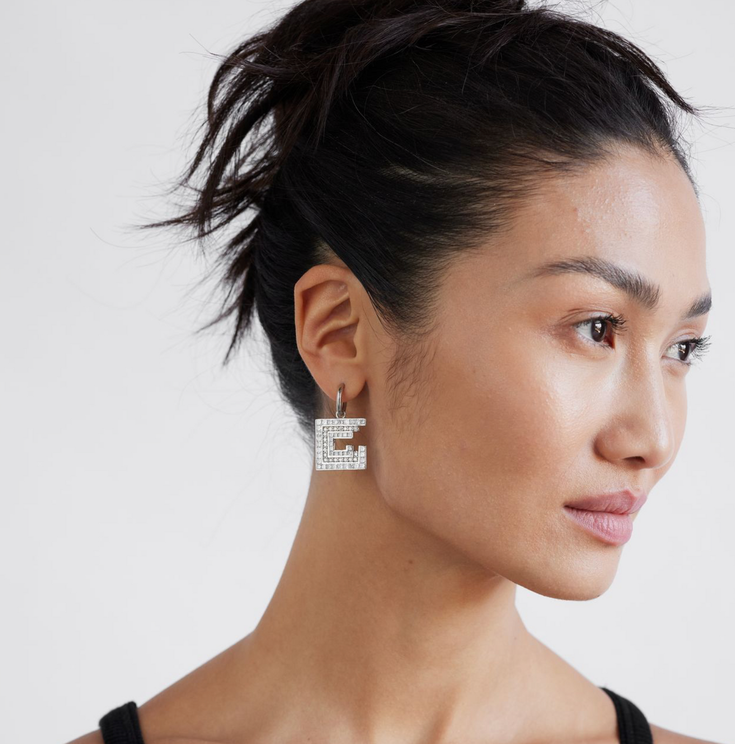 white gold and diamond square and spiral earrings on a model