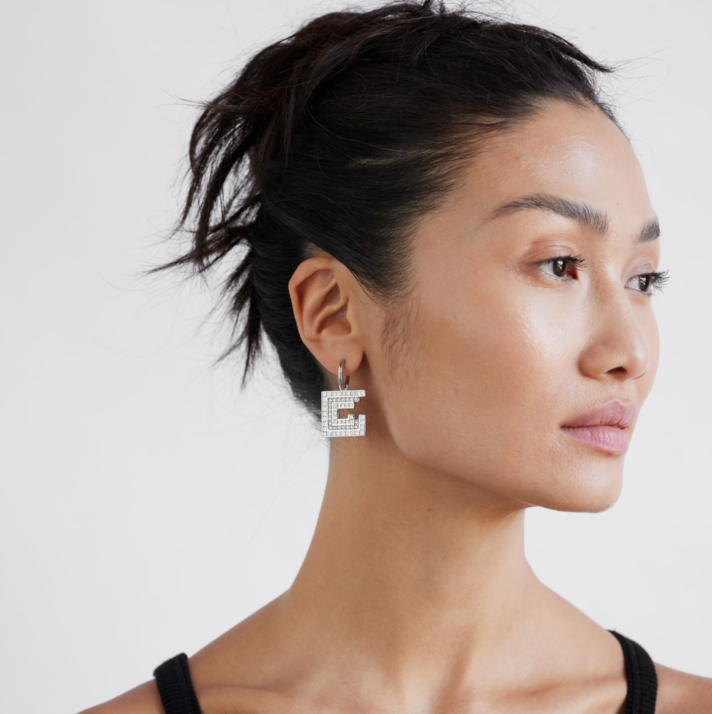model wearing white gold and diamond earrings