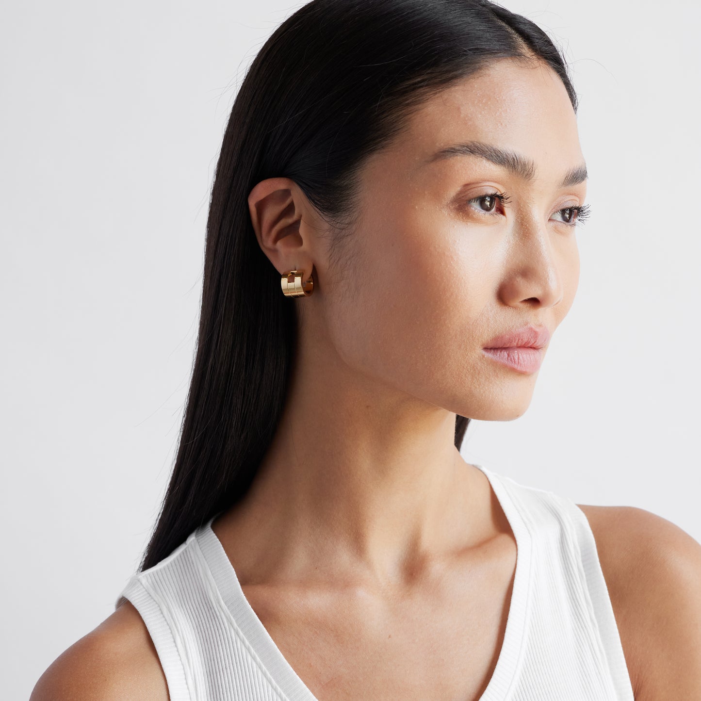 A pair of chunky gold hoop earrings with a geometric design, part of the Margueritte collection.