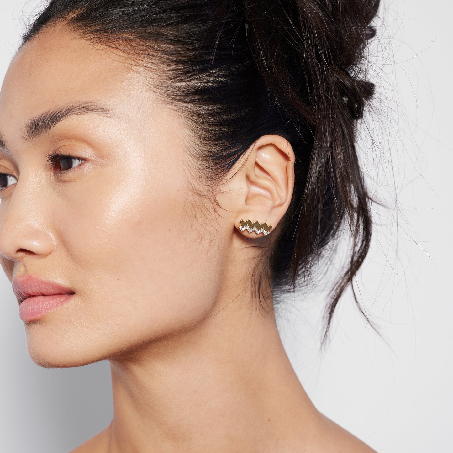 a gold and diamond zig zag stud