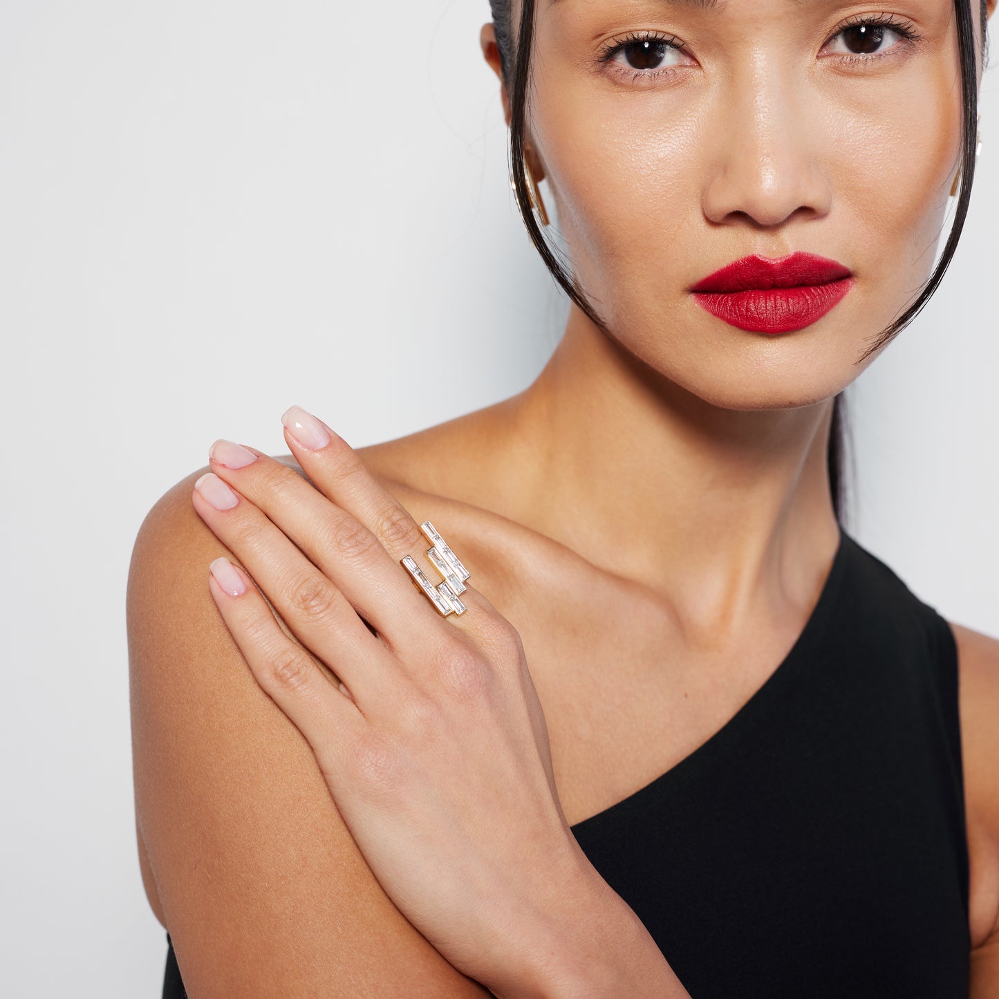 model wearing a chunky yet elegant gold ring with multiple baguette cut diamonds
