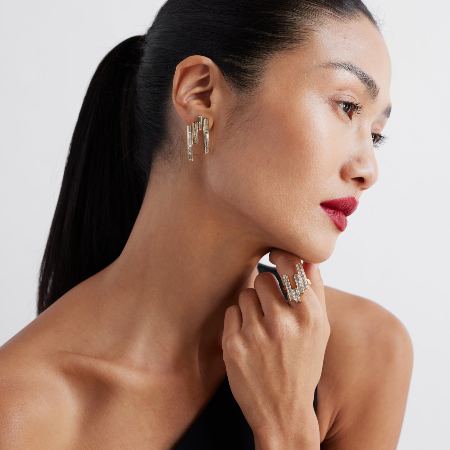 The Tallulah Earrings - gold and baguette diamond earrings on a model