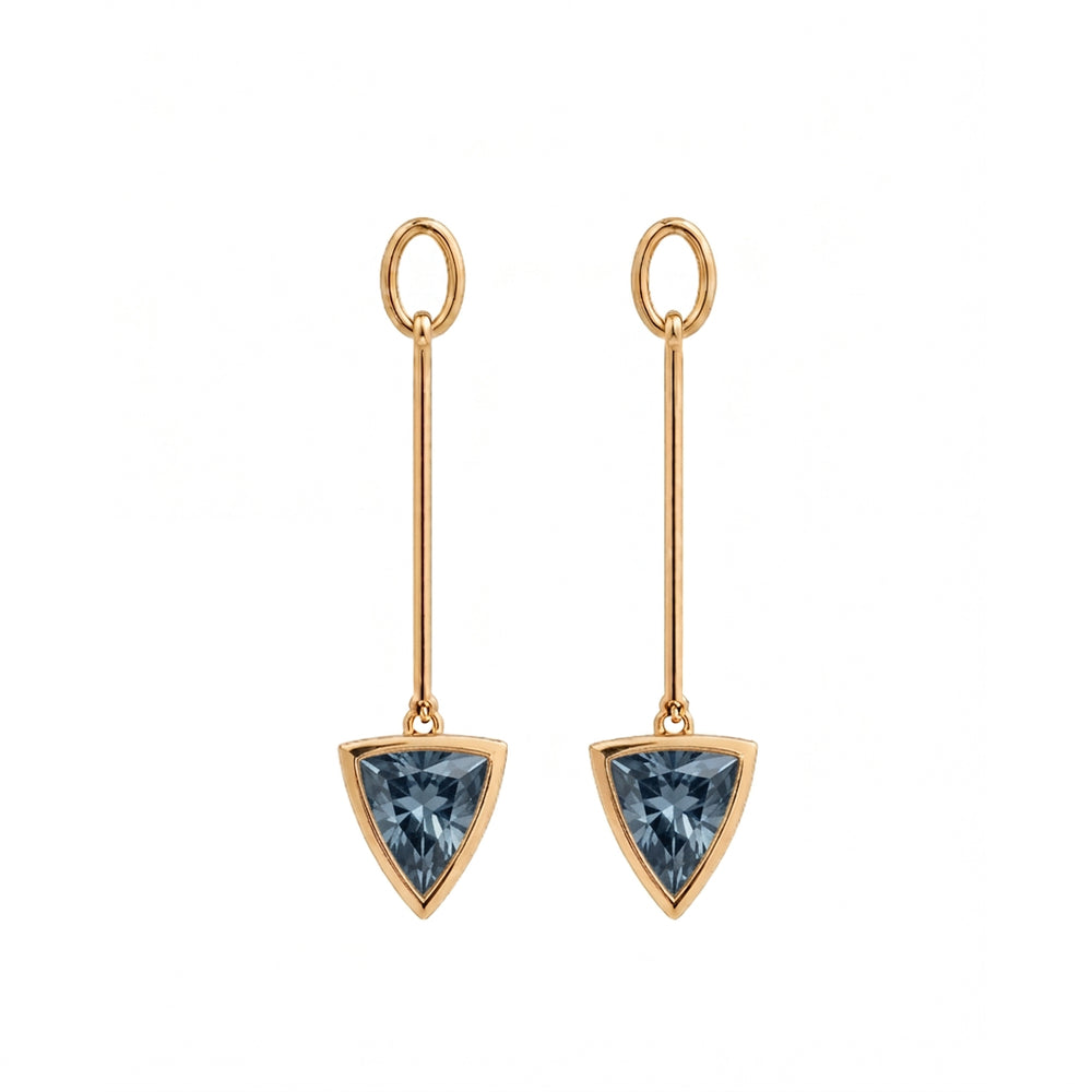 A pair of gold drop earrings featuring a triangular faceted blue spinel gemstone in a gold bezel setting, suspended from a thin vertical bar with a circular top loop, shown on a plain white background.