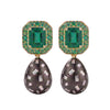 A pair of drop earrings featuring rectangular emerald-cut emeralds surrounded by small green stones in gold-toned settings, with teardrop-shaped dark gray pavé drops set with clear baguette and round stones, shown on a white background.