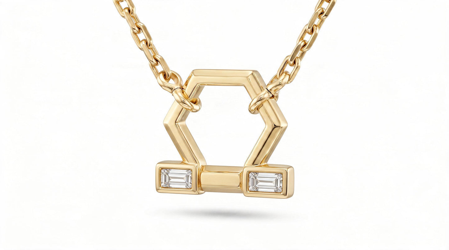 A gold geometric pendant necklace featuring a hexagonal design with two rectangular bezel-set clear baguette diamonds, suspended from a delicate gold chain against a white background.