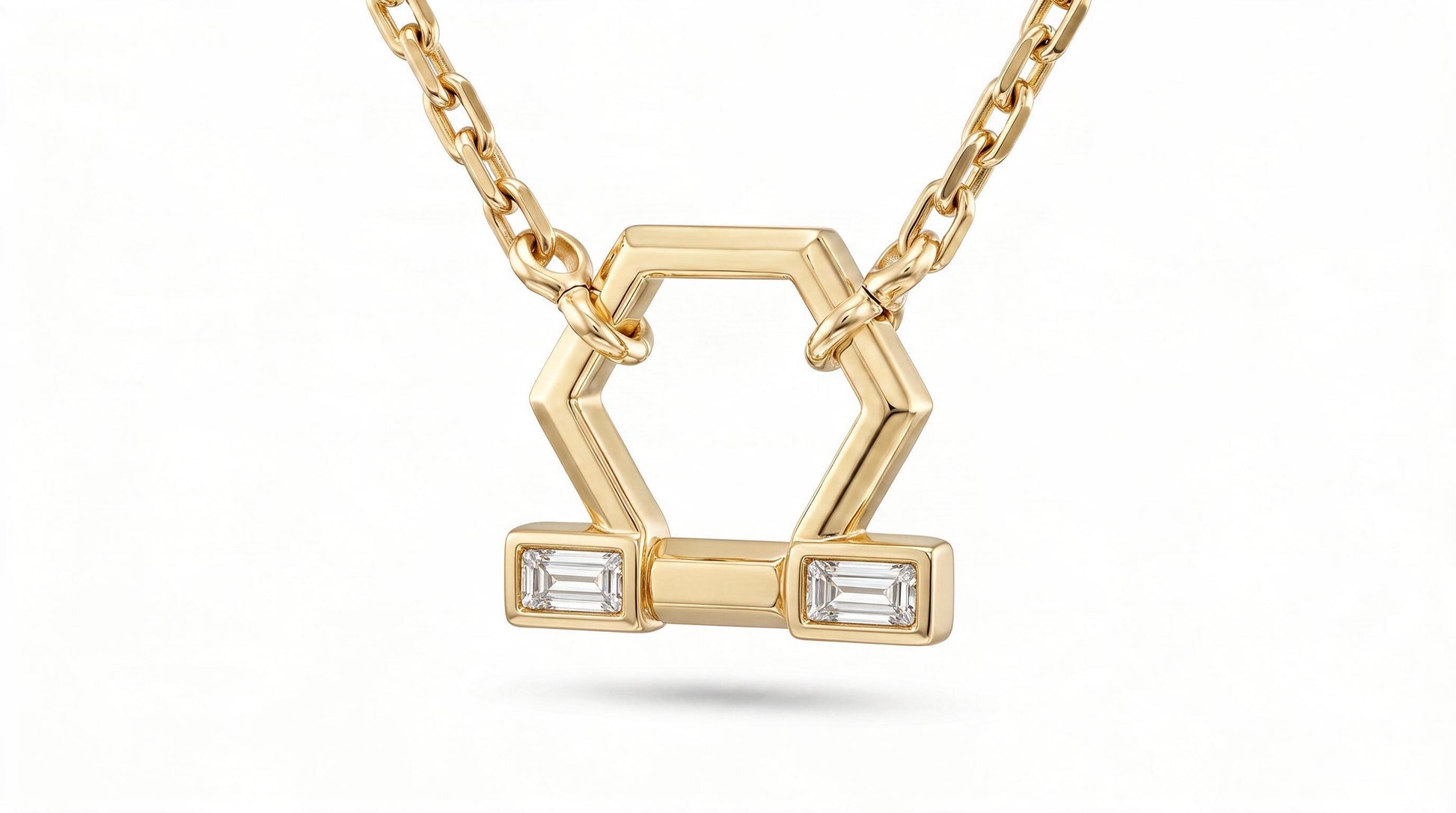 A gold geometric pendant necklace featuring a hexagonal design with two rectangular bezel-set clear baguette diamonds, suspended from a delicate gold chain against a white background.