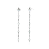 A pair of white gold earrings featuring kite-shaped white diamonds and white enamel details.