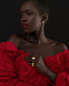 a female model wearing a gold textured pinky ring and a red dress