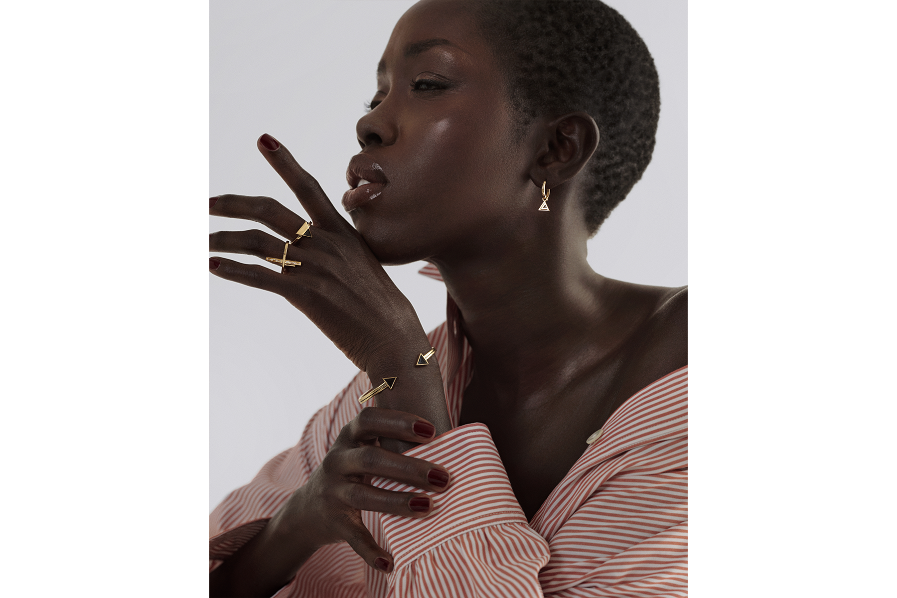 model wearing a gold open bangle with black enamel piping 