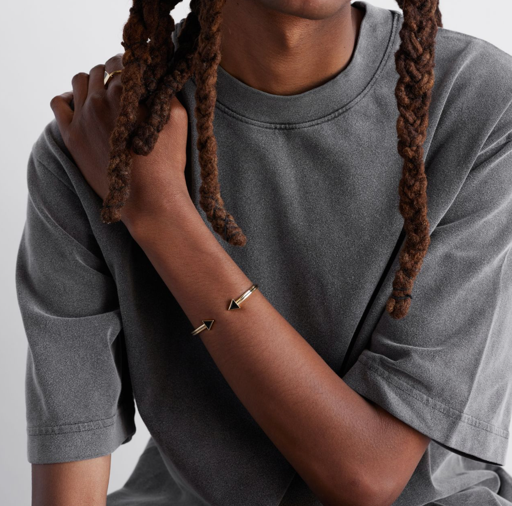 a model shot of a gold bracelet with a chain of linked half-moon crescent shapes, crafted in an Art Deco style.