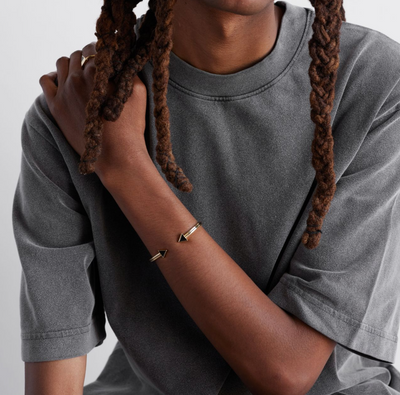 a model shot of a gold bracelet with a chain of linked half-moon crescent shapes, crafted in an Art Deco style.