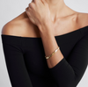 A model shot of a gold bracelet with a chain of linked half-moon crescent shapes, crafted in an Art Deco style.