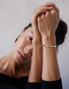 A gold bracelet with a chain of linked half-moon crescent shapes, crafted in an Art Deco style.