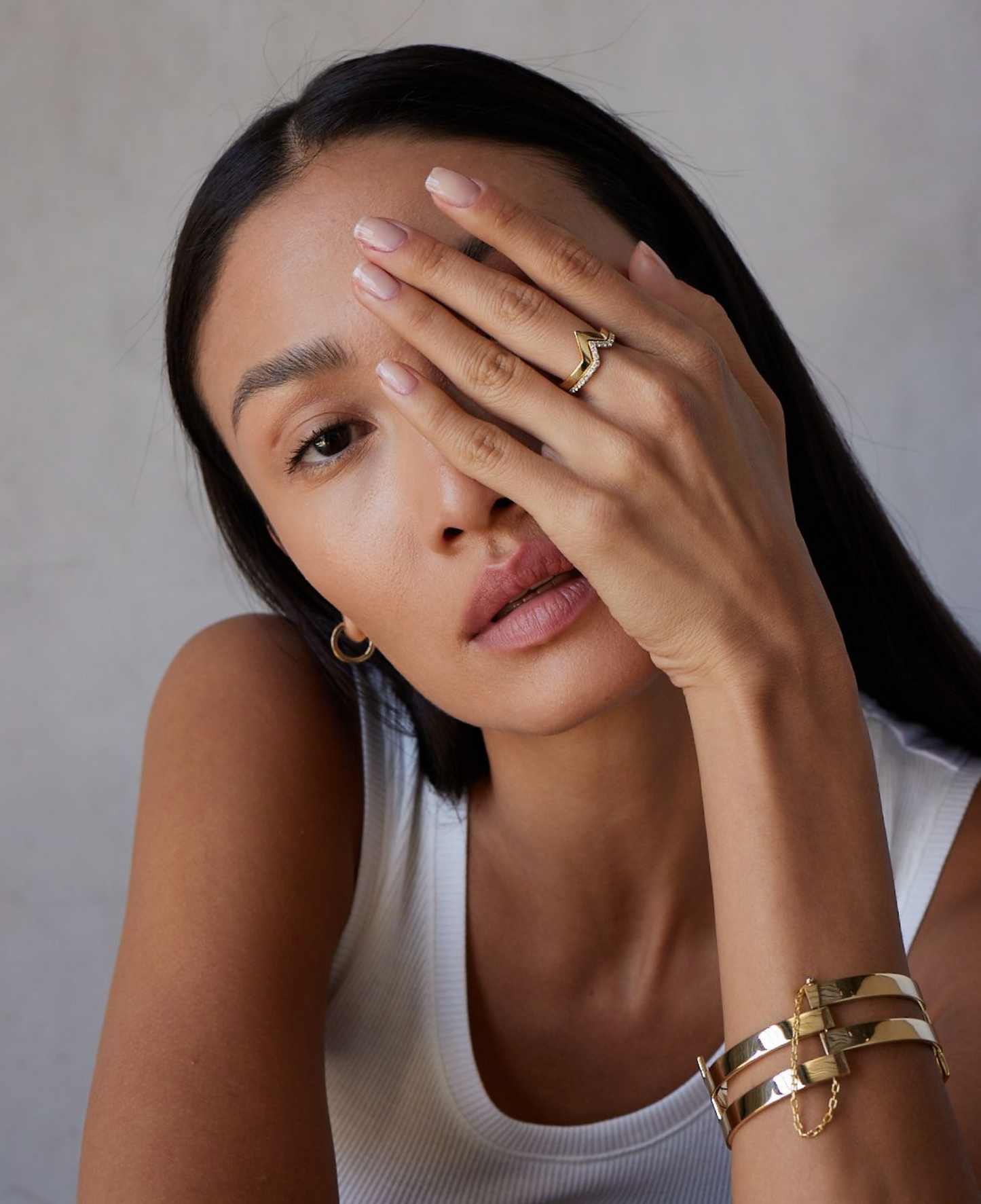 A person showcasing a gold ring with a diamond pave band on their finger.