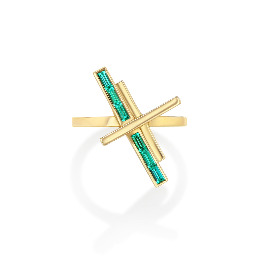 A gold ring with two diagonal bars set with emeralds, positioned across the band.