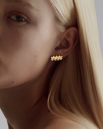 a zigzag diamond and gold stud on a model close up
