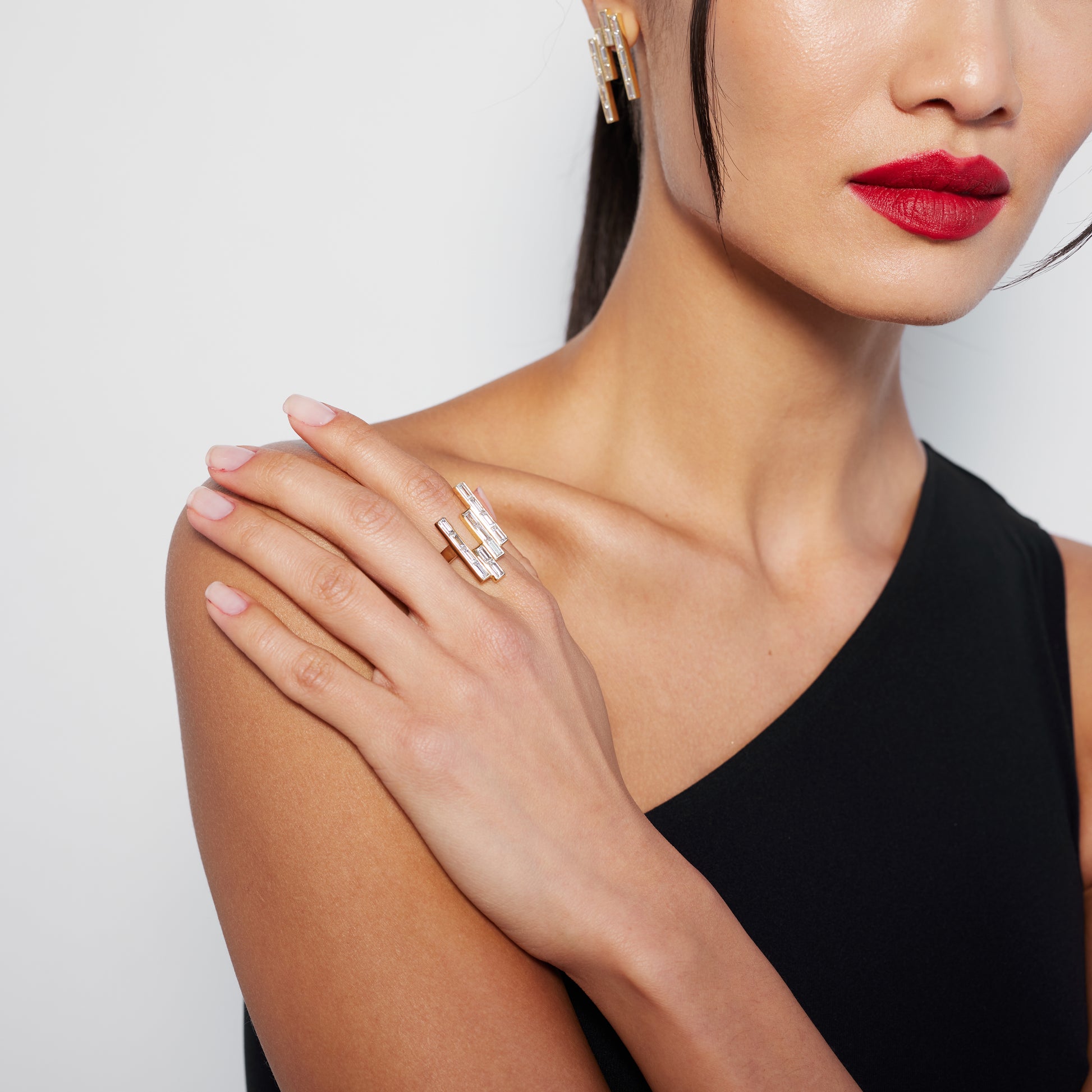 Model wearing a chunky yet elegant gold ring with multiple baguette cut diamonds