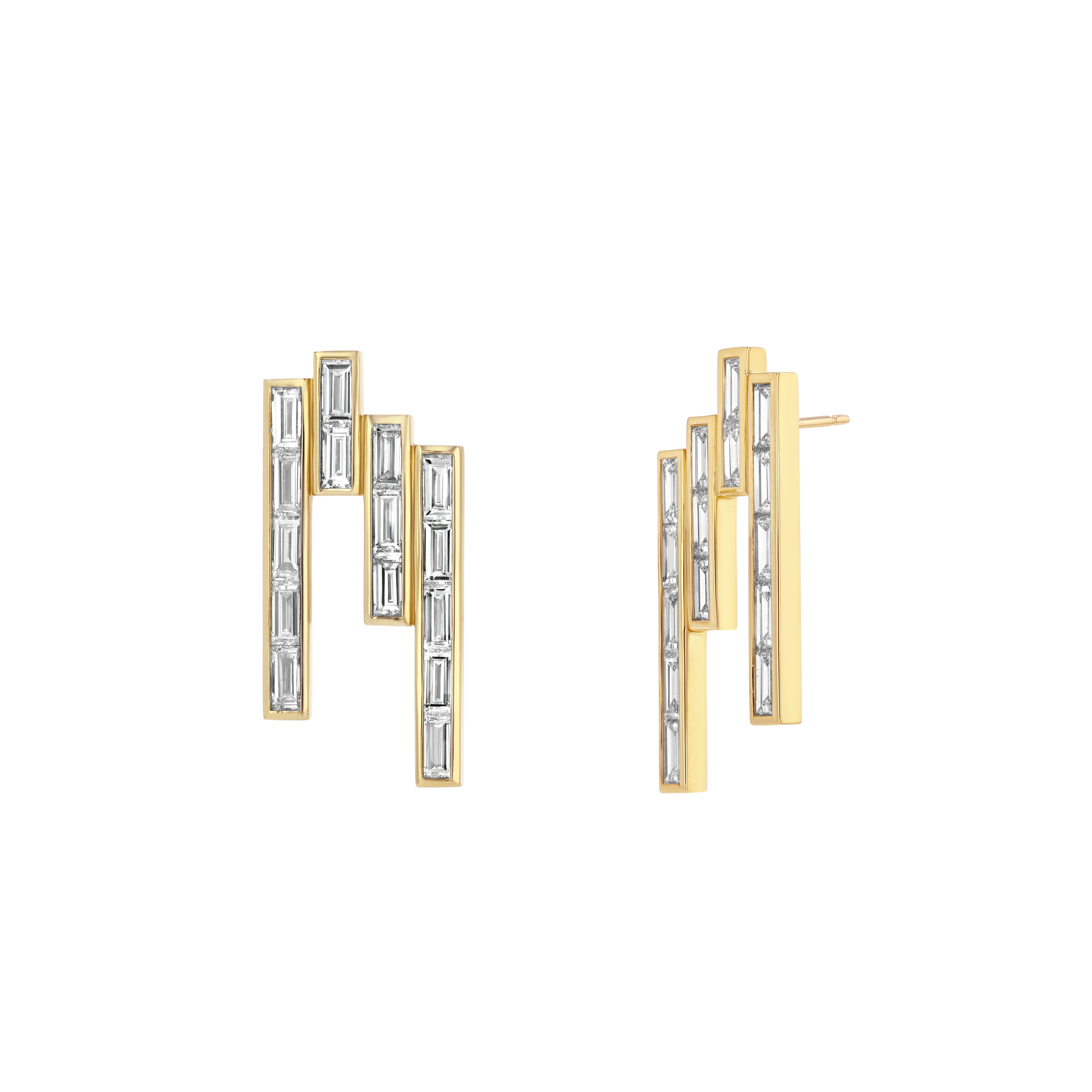 A dramatic pair of gold earrings featuring baguette-cut diamonds arranged in a vertical channel setting.