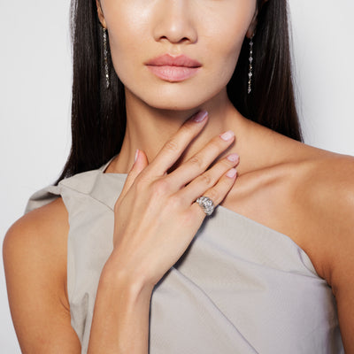 female model wearing a vintage-style dome-shaped ring with a central diamond surrounded by smaller diamonds set in 18k white gold.