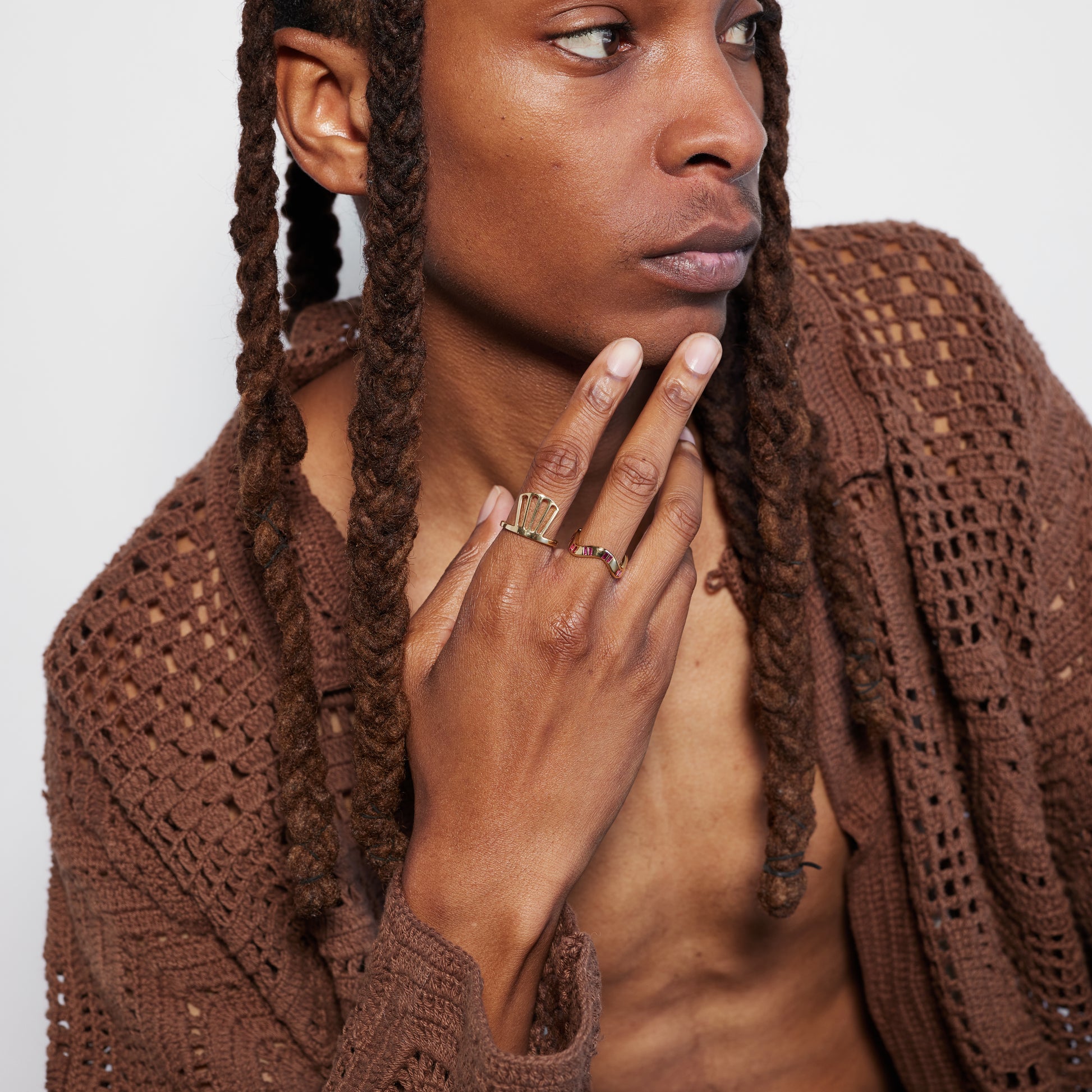 A male model wearing a laser-cut fan-shaped ring made of 18k recycled gold, positioned against a white background.
