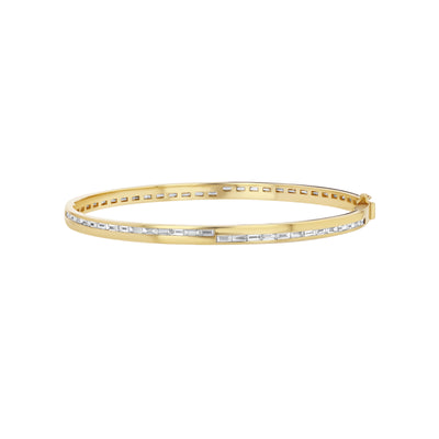 A gold bangle bracelet adorned with baguette-cut diamonds.