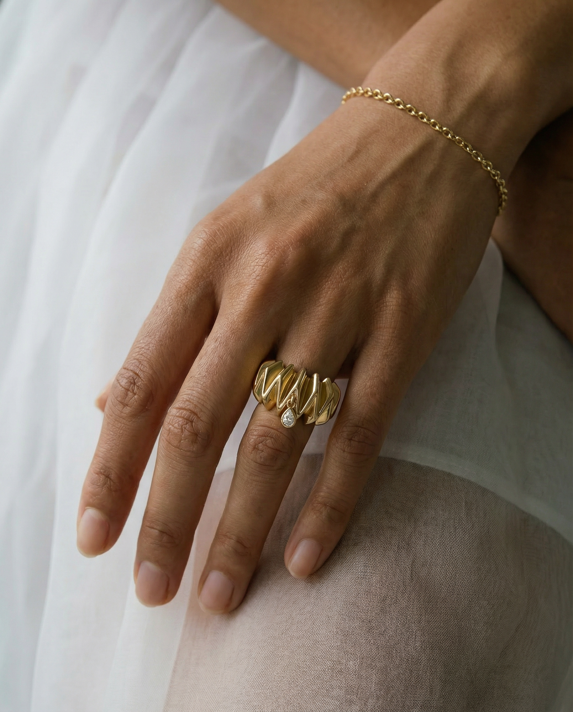 18k gold ring with scrunchie texture set with a bezel set pear shape diamond 