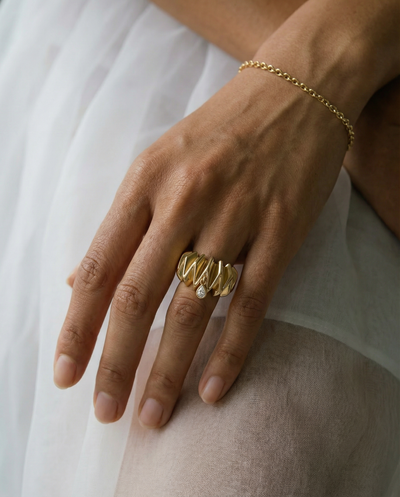 18k gold ring with scrunchie texture set with a bezel set pear shape diamond 