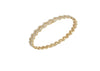Gold bracelet with a zigzag pattern on a white background
